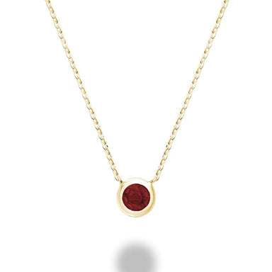 A close-up of a garnet bezel set necklace in 10kt yellow gold. The necklace features a round garnet gemstone that is set in a bezel setting. The gold is a warm yellow color.