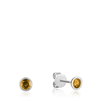 This image features a close-up shot of a Citrine Stud Earring set in 10kt White Gold. The earring features a beautiful, round-cut citrine stone with a vibrant yellow-orange hue. The stone is expertly set in a four-prong setting made of white gold, which adds to the luxurious and elegant look of the earring.