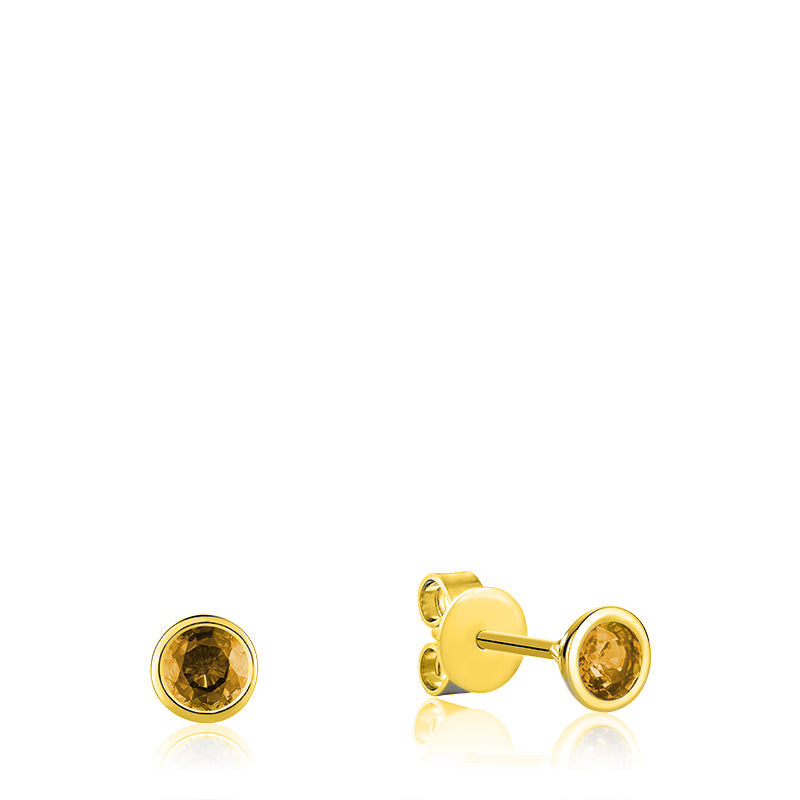 This image showcases a Citrine Stud Earring in 10kt Yellow Gold. The earring features a beautiful, round-cut citrine stone with a vibrant yellow-orange color that catches the light beautifully. The stone is held in place by a four-prong setting made of yellow gold, which adds to the luxurious and elegant look of the earring.
