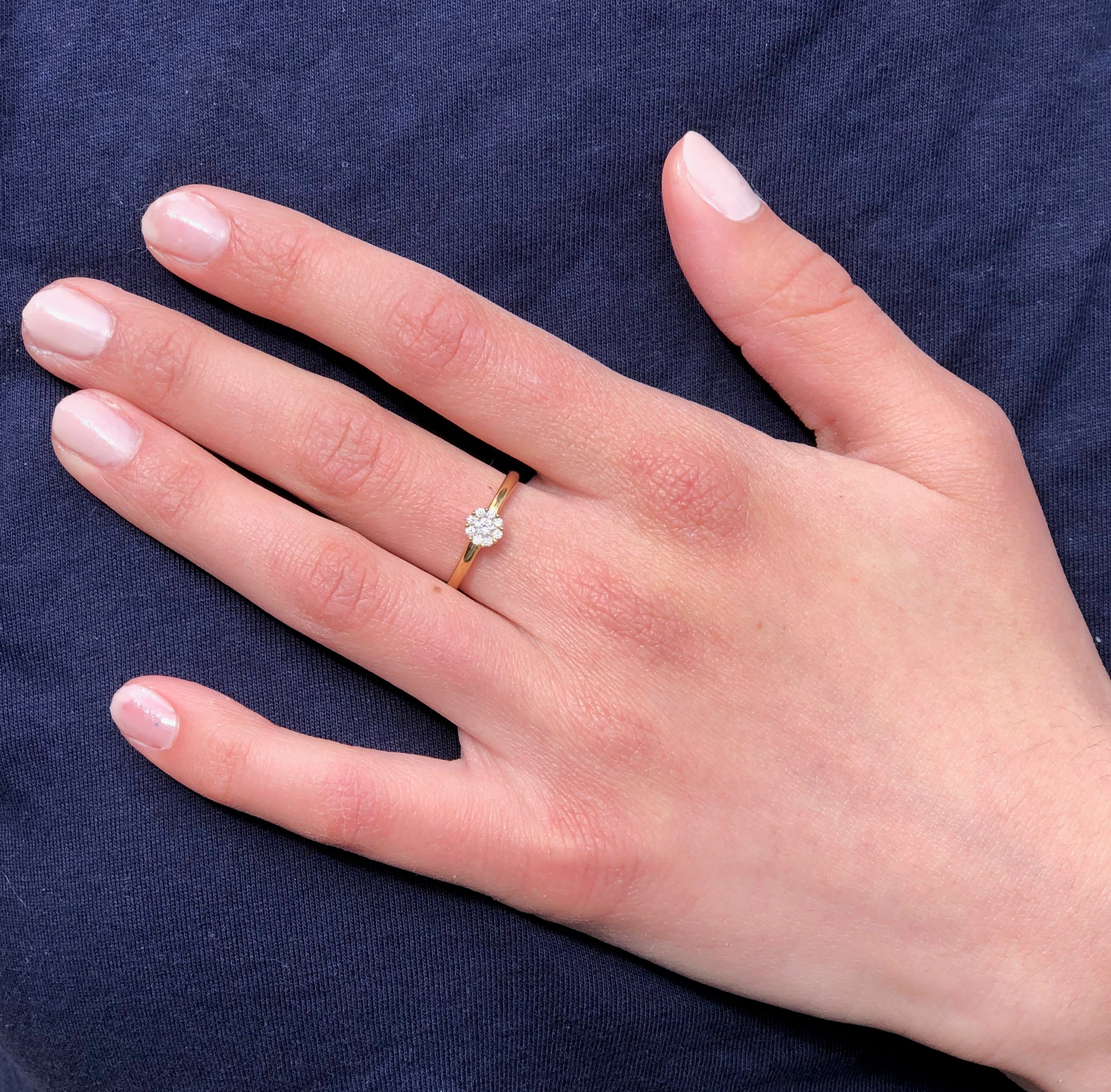Yellow Gold Diamond Cluster Ring on Woman's Hand: A close-up view of a woman's hand elegantly displaying the timeless yellow gold ring adorned with a sparkling diamond cluster, highlighting its sophisticated beauty and charm.