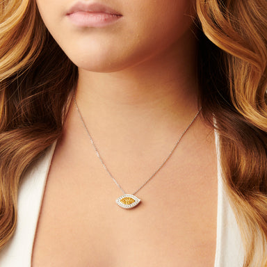 A woman elegantly wears the Evil Eye Fancy Yellow Diamond and White Diamond Pendant, its brilliant shine complementing her style.