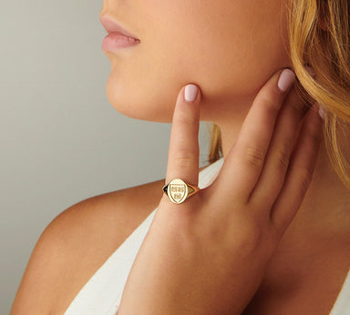 Side view of a woman wearing a 14kt solid yellow gold Harvard Mini Scooped Class Ring on her finger, with the ring's intricate details clearly visible.