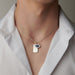 This image shows a man wearing an Evil Eye Blue Sapphire and Diamond Pendant. The pendant is centered on the man's neck and is the focus of the image. 