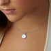 A woman wearing a sterling silver Harvard Ivy Pendant, highlighting its sophisticated design and timeless beauty.