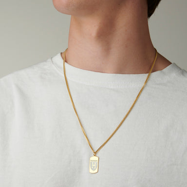 Gold vermeil Harvard Squadra Pendant elegantly worn by a man, highlighting the pendant's luxurious shine and craftsmanship.