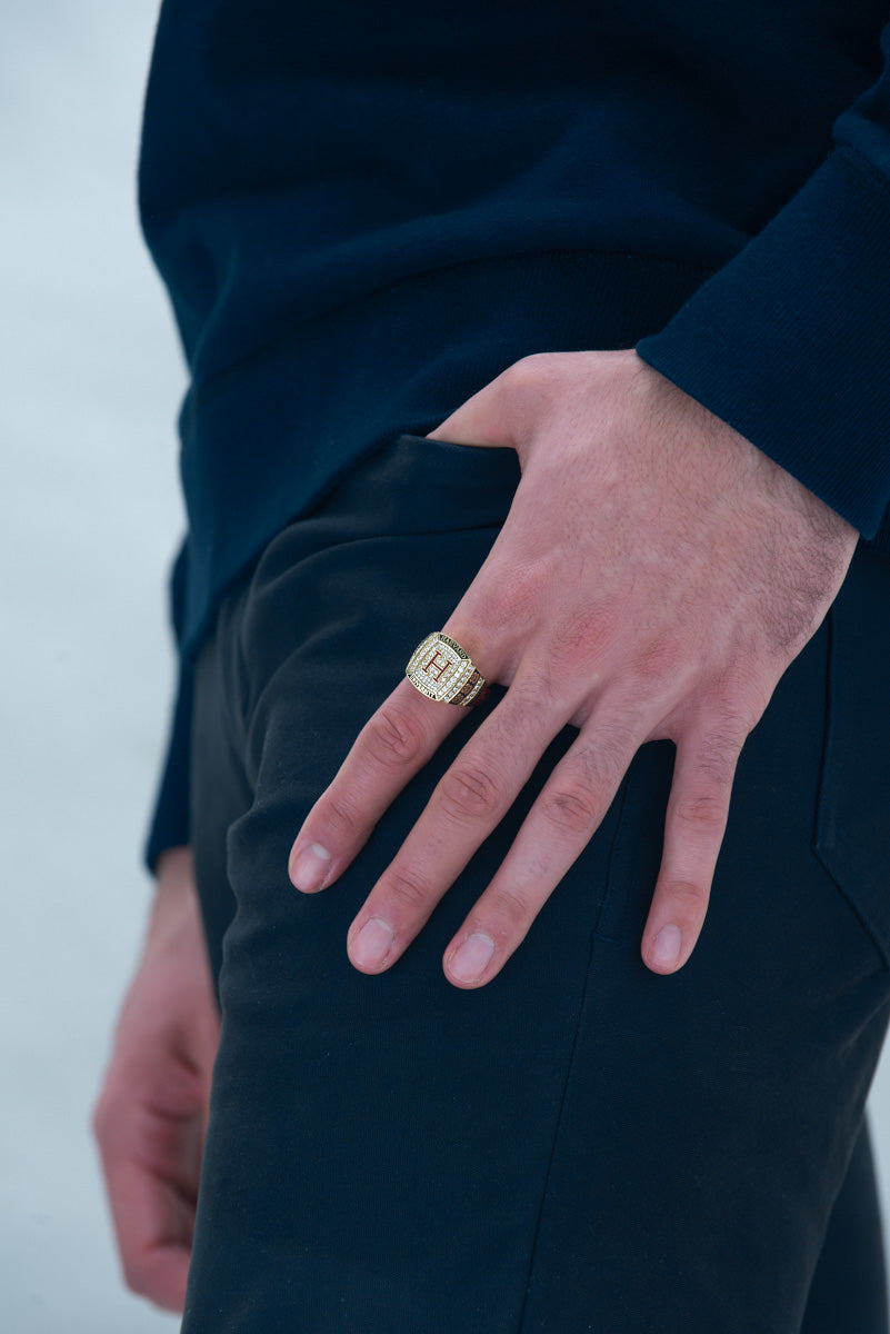 A man proudly wears the Harvard Limited Edition Veritas Class Ring on his index finger, symbolizing his affiliation with Harvard University and academic achievement.